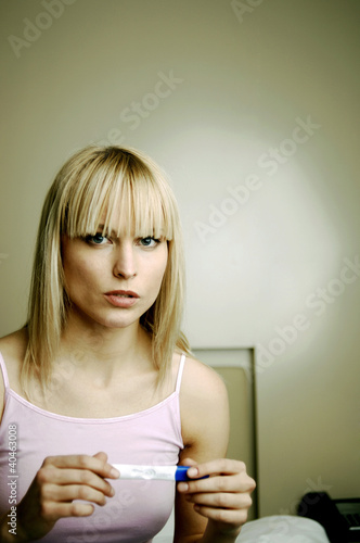 Photo: Woman checking her pregnancy test result. Woman checking her pregnancy test result.