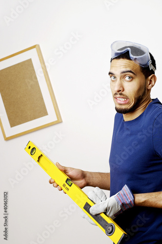 Photo: Man with goggles holding a spirit level. Man with goggles holding a spirit level.