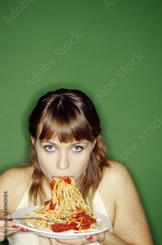 Photo: Woman eating spaghetti. Woman eating spaghetti.