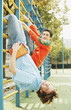 Boys hanging on gymnastic bars.
