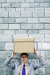 Businessman carrying a box on his head.