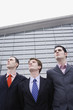 Photo: Three businessmen standing in a row. Three businessmen standing in a row.