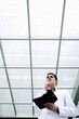 Businessman thinking while holding an organizer.