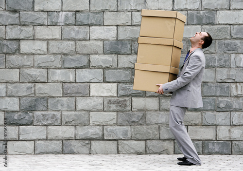 Photo: Businessman carrying a stack of boxes. Businessman carrying a stack of boxes.