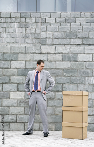Photo: Businessman looking at a stack of boxes. Businessman looking at a stack of boxes.