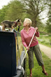 Senior woman playing with her dog while mopping her houseboat