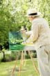 Photo: Senior man painting in the park Senior man painting in the park