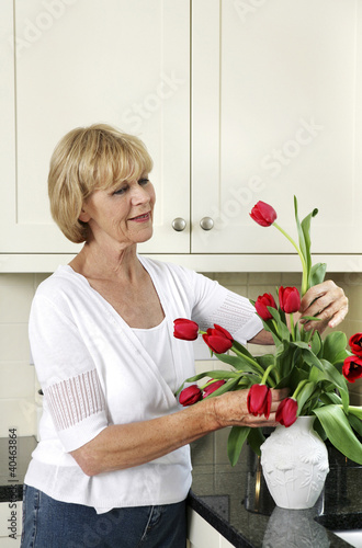 Photo: Senior woman arranging flowers Senior woman arranging flowers