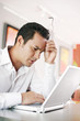 Man resting his head while using laptop