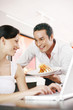 Woman getting a delicious dish from her boyfriend while using laptop