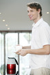 Foto: Man holding a cup and a saucer Man holding a cup and a saucer