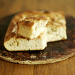 Fresh Italian focaccia bread with broken piece on top
