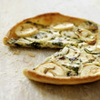 Italian goats cheese and spinach quiche with slice missing
