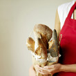 Woman holding a selection of fresh Italian rustic bread, one with poppy seeds