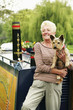 Senior woman posing with her dog on the houseboat