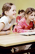 Girls smiling while paying attention in the classroom