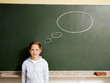 Girl standing in front of a blackboard with thought bubble