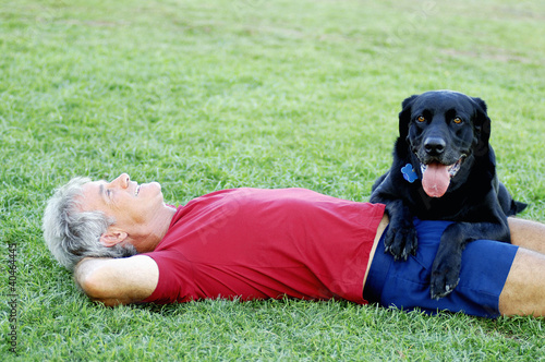 Foto: Senior man and his dog relaxing in the park Senior man and his dog relaxing in the park
