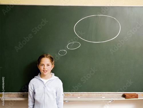 Foto: Girl standing in front of a blackboard with thought bubble Girl standing in front of a blackboard with thought bubble