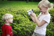 Girl recording the images of little boy