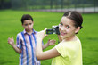 Girl recording images of boy making a face