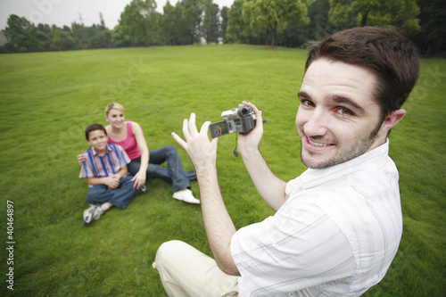 Photo: Man recording images of boy and girl Man recording images of boy and girl