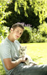 Young man holding a cat in his arms