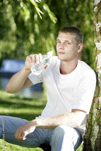 Foto: Young man drinking bottled water Young man drinking bottled water