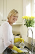 Senior woman washing dishes in the sink