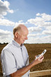Photo: Senior man reading a message on his mobile phone Senior man reading a message on his mobile phone