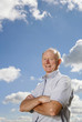 Photo: Senior man folding his arms while smiling at the camera Senior man folding his arms while smiling at the camera