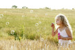 Girl blowing bubbles in the field