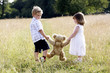 Children holding a teddy bear