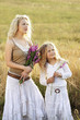 Photo: Woman and girl holding flowers, staring Woman and girl holding flowers, staring