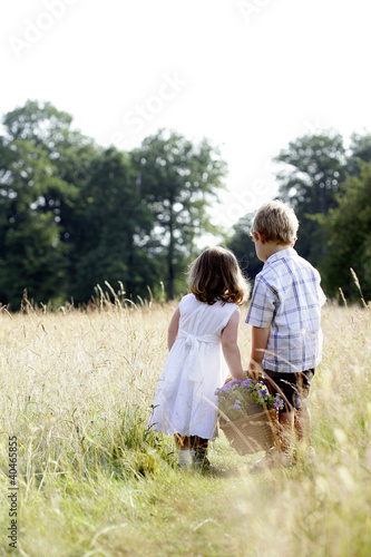 Foto: Little girl and little boy carrying a basket of flowers Little girl and little boy carrying a basket of flowers