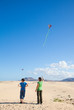 mother and son fly a kite at natural reserve dunes of Corralejo,