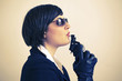 Photo : Woman with sunglasses blowing pistol Woman with sunglasses blowing pistol