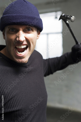 Foto: Angry burglar attacking with a hammer Angry burglar attacking with a hammer