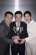 Business people posing with their trophy