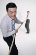 Businessmen playing tug of war