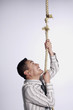 Businessman climbing a tearing rope