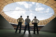 Three businessmen standing at the stadium