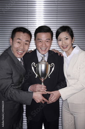 Photo: Business people posing with their trophy Business people posing with their trophy