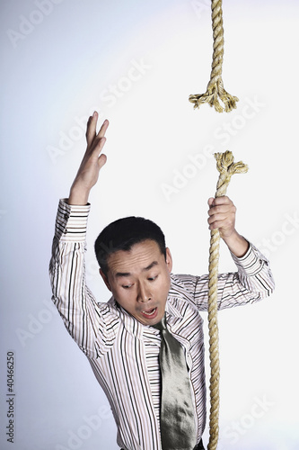Photo: Businessman falling from broken rope Businessman falling from broken rope