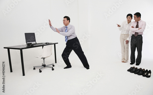 Photo: Businessman doing tai chi in his office Businessman doing tai chi in his office