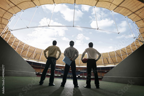 Photo: Three businessmen standing at the stadium Three businessmen standing at the stadium
