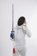 Confused man in fencing suit holding a sword