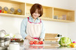 Foto: Beautiful young woman in kitchen making salad. Portrait of asian Beautiful young woman in kitchen making salad. Portrait of asian