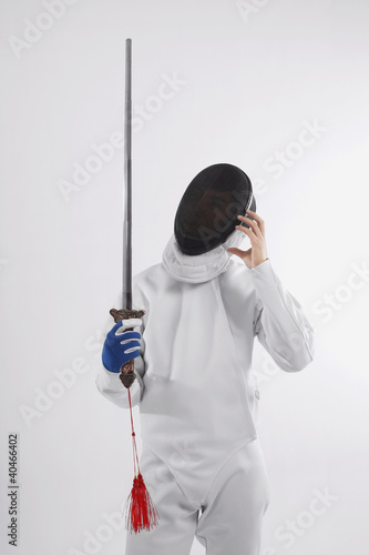 Photo: Confused man in fencing suit holding a sword Confused man in fencing suit holding a sword