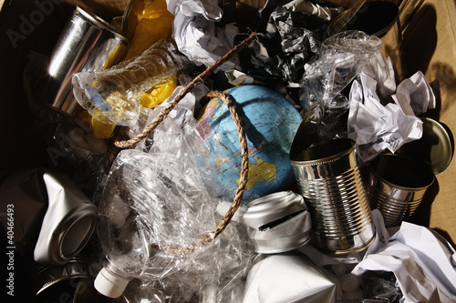 Photo: Cardboard box filled with plastic bottles, tin cans, papers, rope and a globe Cardboard box filled with plastic bottles, tin cans, papers, rope and a globe